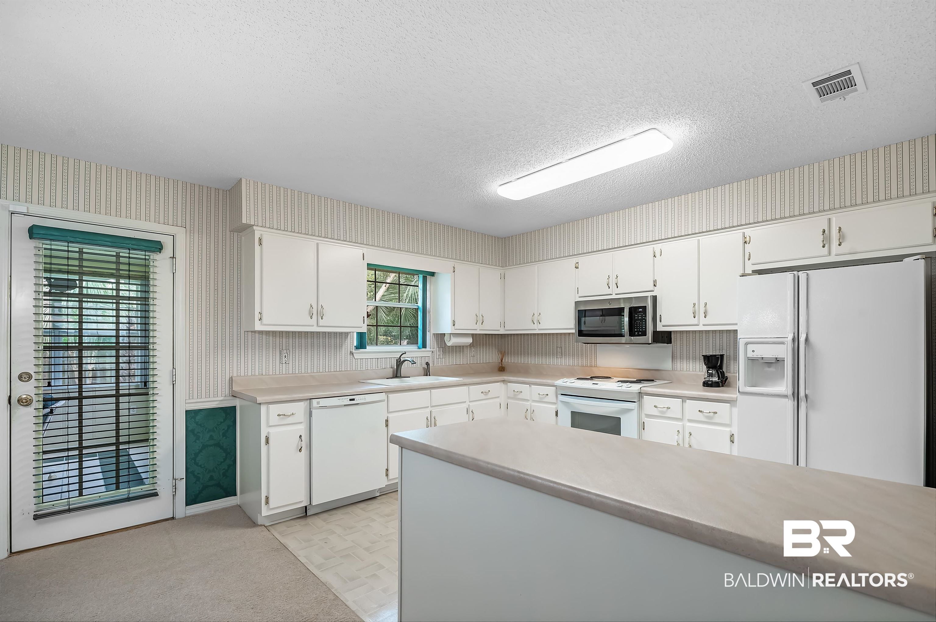 1502 Mulberry Lane Foley, AL 36535 - Photo 17 of 45 Kitchen featuring sink, a textured ceiling, light colored carpet, and white appliances