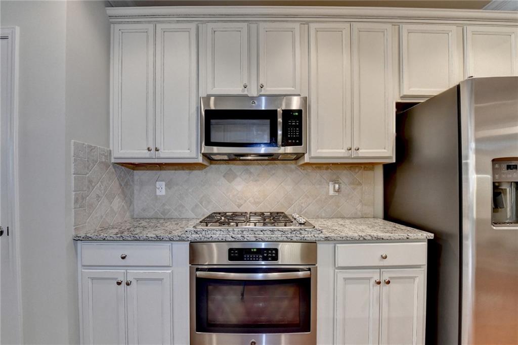2583 Madison Mae Lane Grayson, GA 30017 - Photo 11 of 43 a kitchen with stainless steel appliances granite countertop white cabinets and a stove
