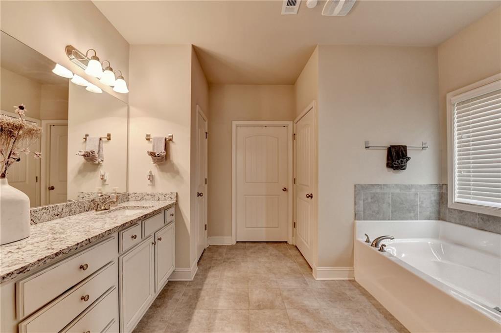 2583 Madison Mae Lane Grayson, GA 30017 - Photo 26 of 43 a spacious bathroom with a granite countertop tub sink and mirror