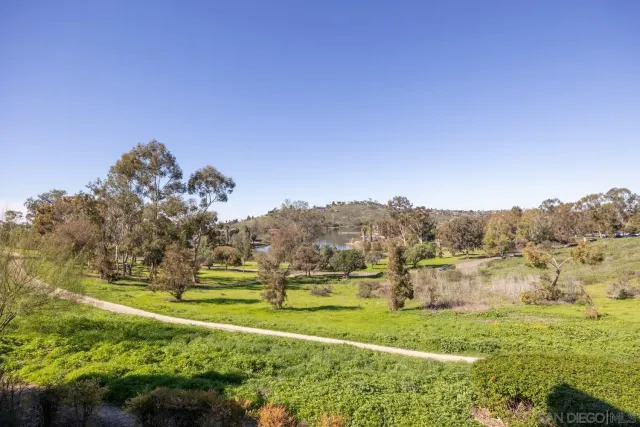 a view of a large buildings with big yard and large trees