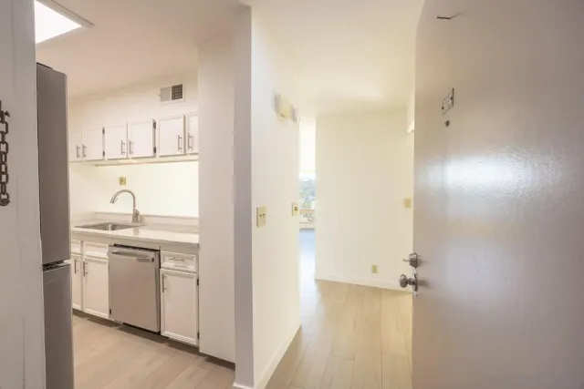 a kitchen with granite countertop a sink and white cabinets