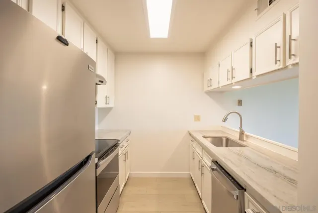 a kitchen with stainless steel appliances granite countertop a refrigerator and a sink