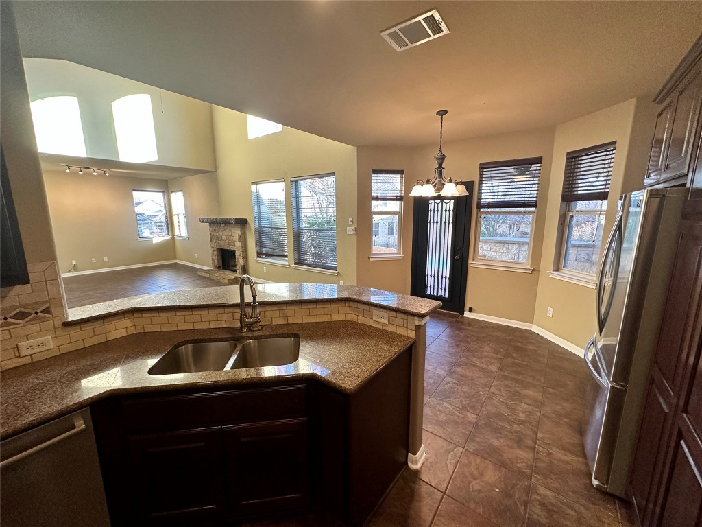 3713 Broadwinged Hawk Cove Austin, TX 78738 - Photo 14 of 37 a kitchen with a sink refrigerator and window