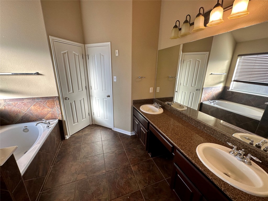 3713 Broadwinged Hawk Cove Austin, TX 78738 - Photo 27 of 37 a bathroom with a double vanity sink and mirror