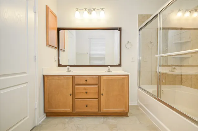 a bathroom with a bathtub a mirror a sink and vanity