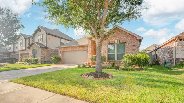a view of a house with a big yard and large trees