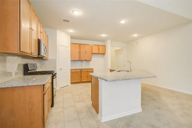 a kitchen with stainless steel appliances granite countertop a sink stove and cabinets