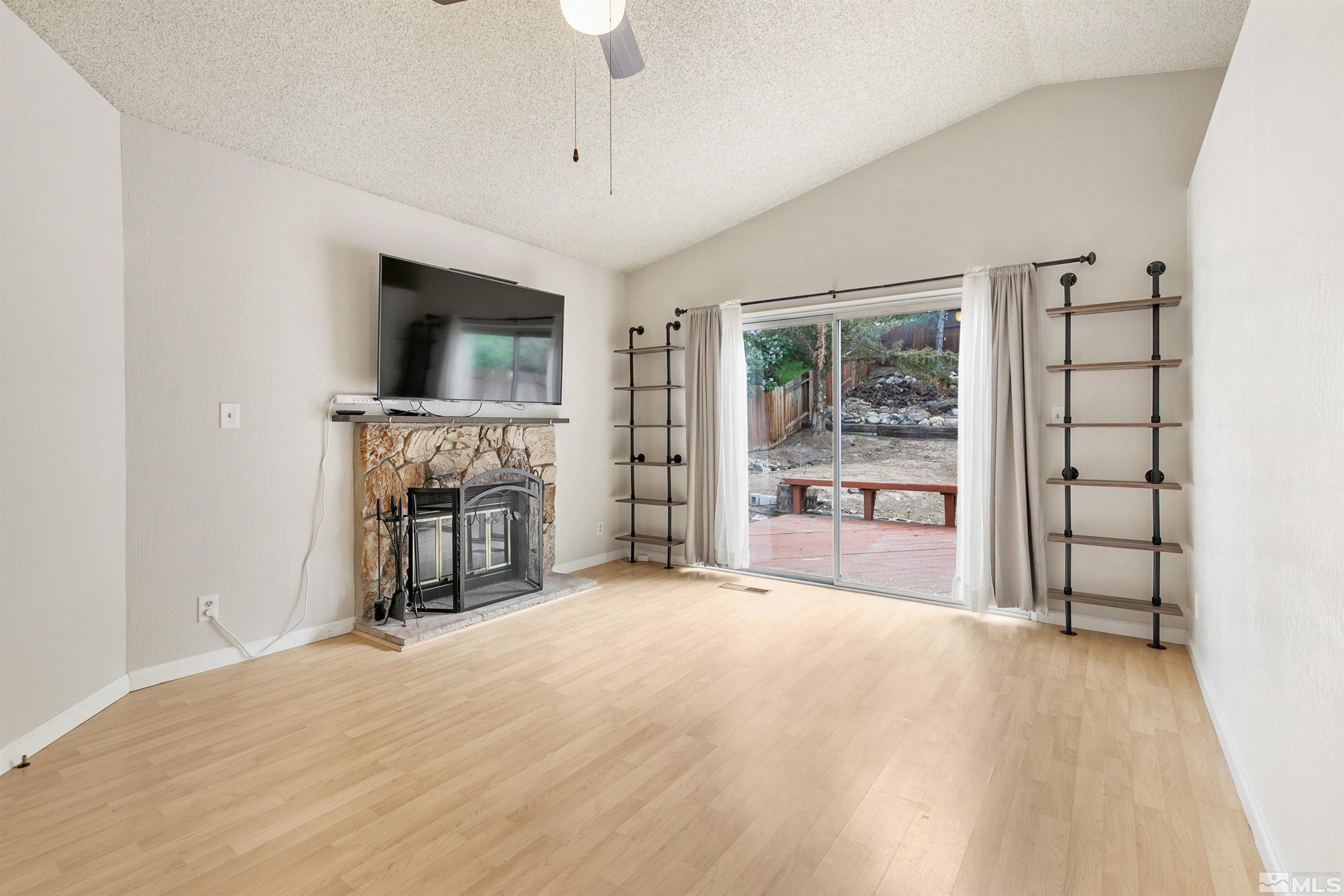 1394 Ambassador Drive Reno, NV 89523 - Photo 11 of 28 a view of an empty room with a fireplace and a window