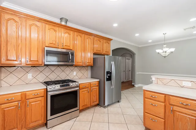 a kitchen with stainless steel appliances granite countertop a stove top oven microwave and refrigerator