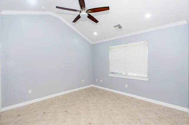 an empty room with a window and a fan