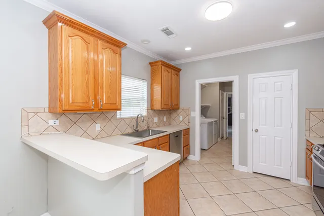 a kitchen with a sink a refrigerator and cabinets