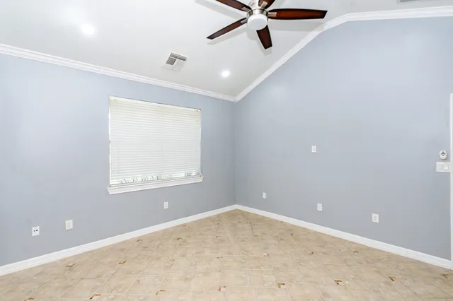an empty room with a window and a fan
