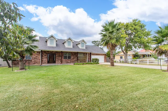 a front view of a house with a garden and plants
