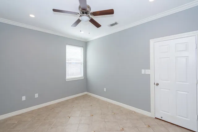 en empty room with windows and ceiling fan