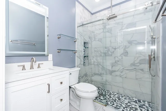a bathroom with a sink toilet vanity and shower