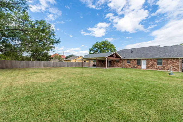 a view of a house with a big yard and large trees