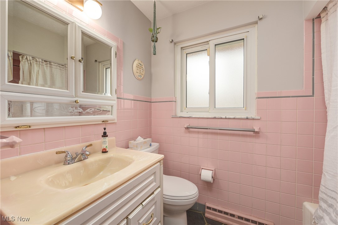 1103 Old Rockside Road Cleveland, OH 44134 - Photo 20 of 25 Bathroom with a wainscoted wall, toilet, curtained shower, vanity, and a baseboard heating unit