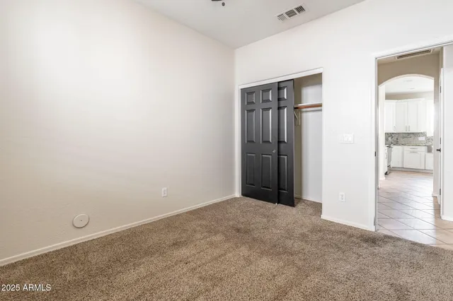 an empty room with closet and wooden floor