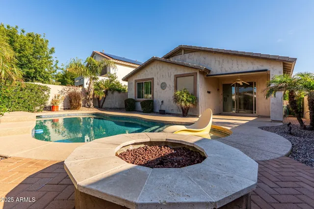a view of a house with swimming pool and sitting area