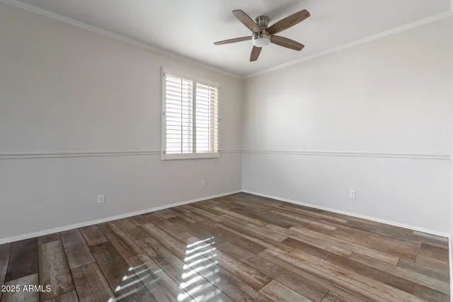 a view of a big room with wooden floor and windows