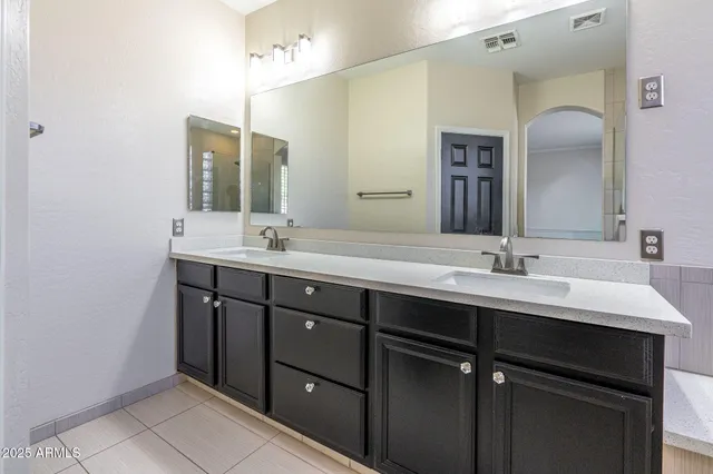 a bathroom with a double vanity sink and a mirror
