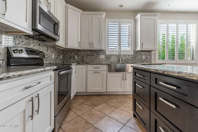a kitchen with stainless steel appliances granite countertop a stove sink microwave and cabinets