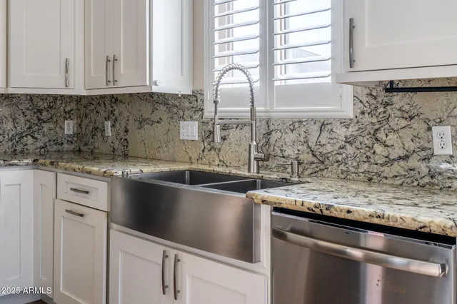 a kitchen with granite countertop a sink and a window