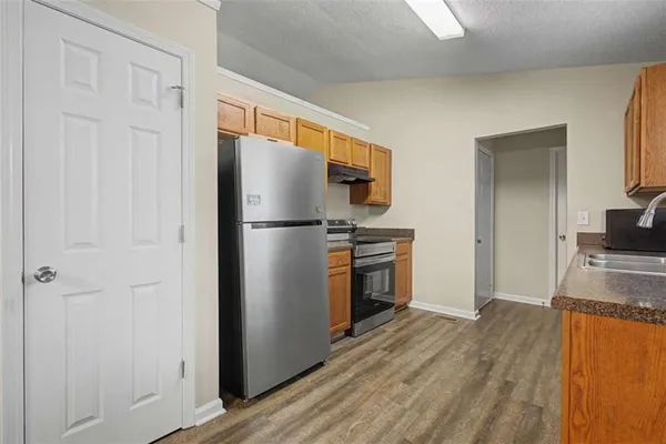 a kitchen with a refrigerator a stove and a sink