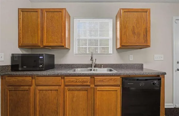 a kitchen with granite countertop cabinets sink and window