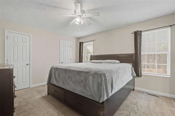a spacious bedroom with a bed and a chandelier