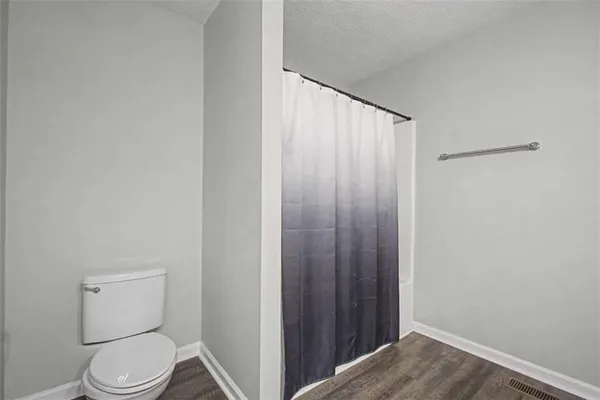 a white toilet sitting next to a shower