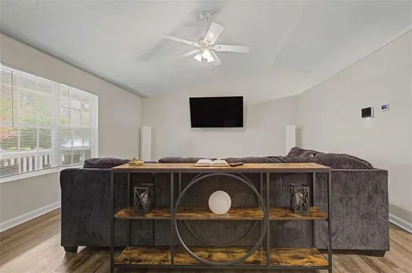 a living room with furniture a flat screen tv and a floor to ceiling window