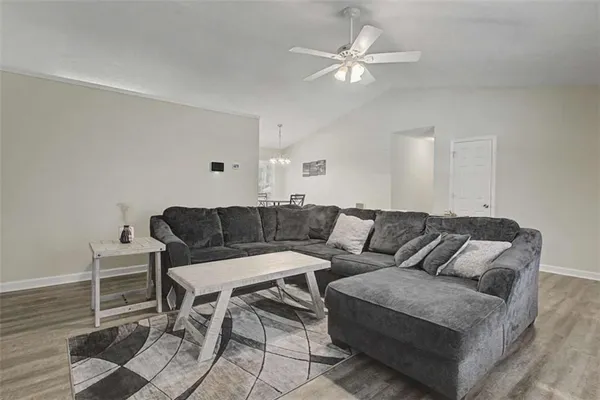 a living room with furniture and a ceiling fan