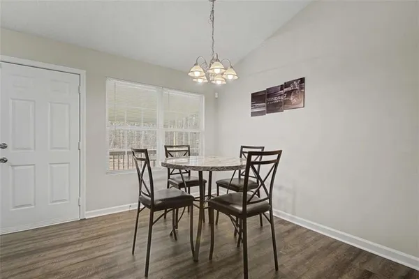 a view of a dining room with furniture wooden floor and a chandelier