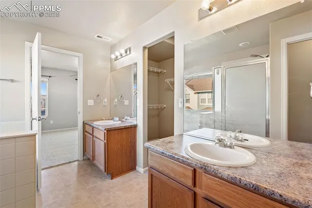 a bathroom with a granite countertop sink a mirror and a bathtub