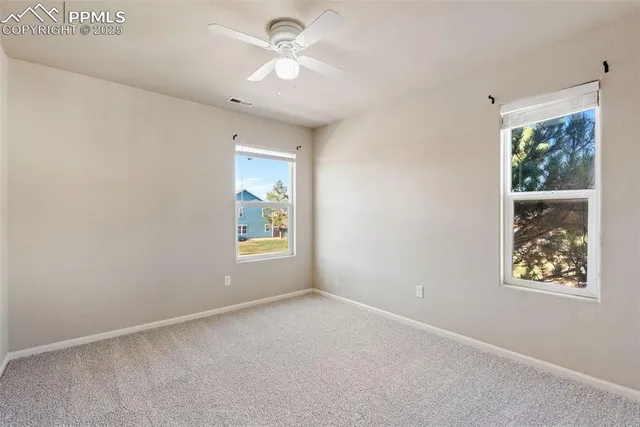 an empty room with a ceiling fan and a window