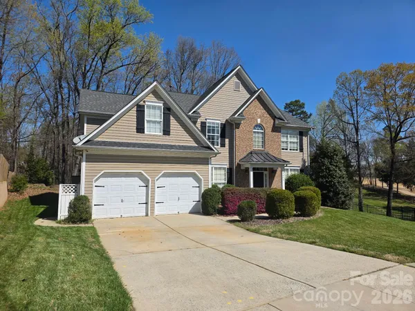 a front view of a house with a yard and trees