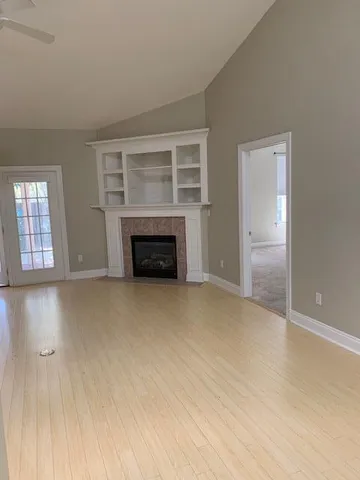 an empty room with fireplace and a window
