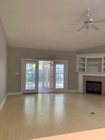 a view of an empty room with a fireplace and a window