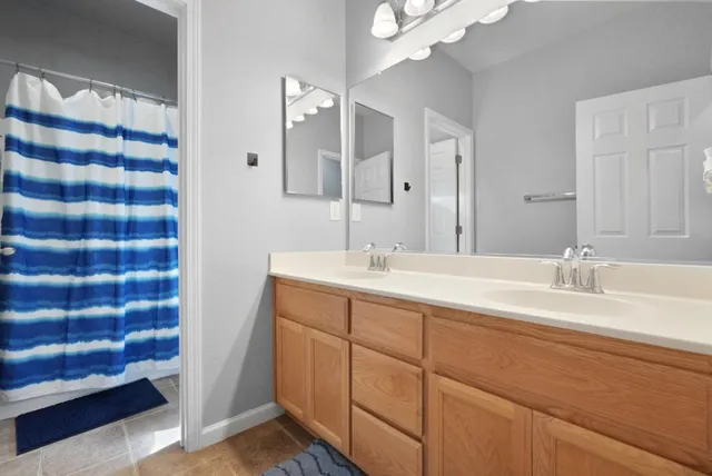 a bathroom with a double vanity sink and a mirror