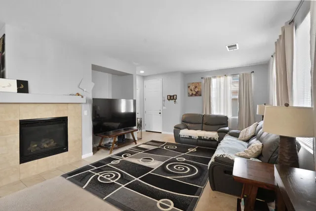 a living room with furniture a fireplace and a flat screen tv
