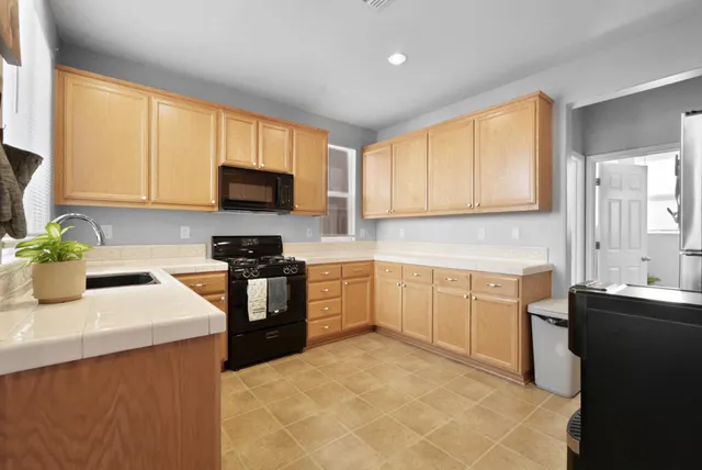 a kitchen with a sink stove top oven and microwave