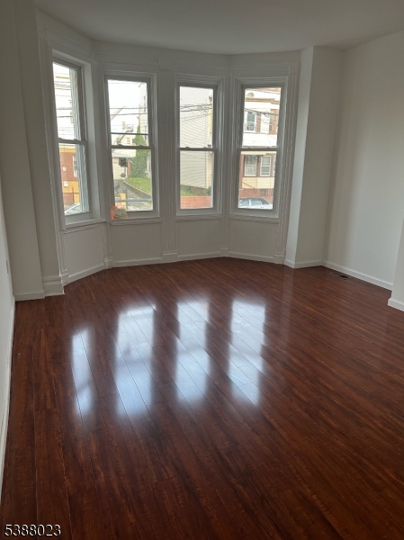 247 South 8th Street, Unit 1 Newark, NJ 07103 - Photo 12 of 13 an empty room with wooden floor and windows