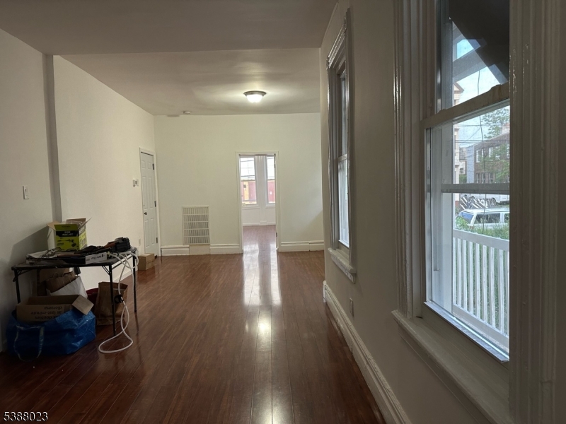 247 South 8th Street, Unit 1 Newark, NJ 07103 - Photo 2 of 13 a view of a hallway with wooden floor and furniture in a room