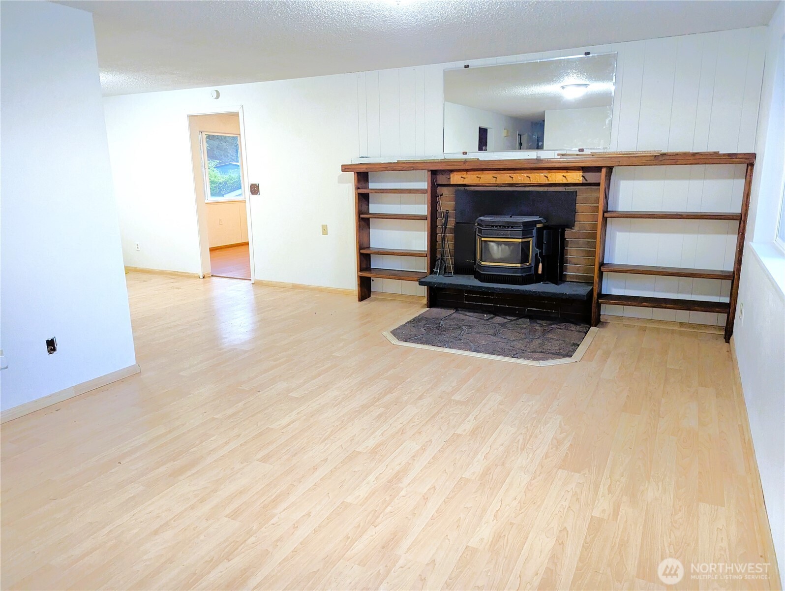 8927 178th Avenue Southwest Rochester, WA 98579 - Photo 8 of 38 a view of an empty room with a fireplace and a window