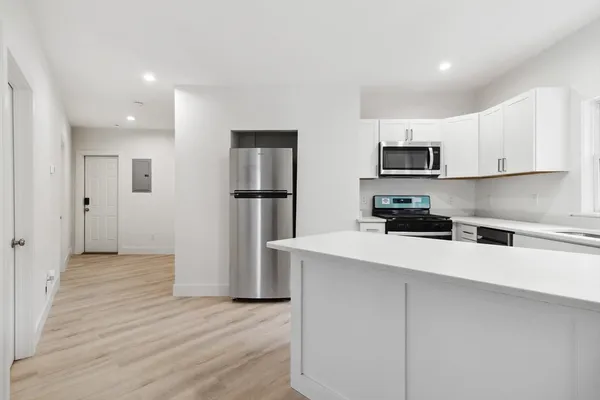 a kitchen with stainless steel appliances a refrigerator sink and white cabinets