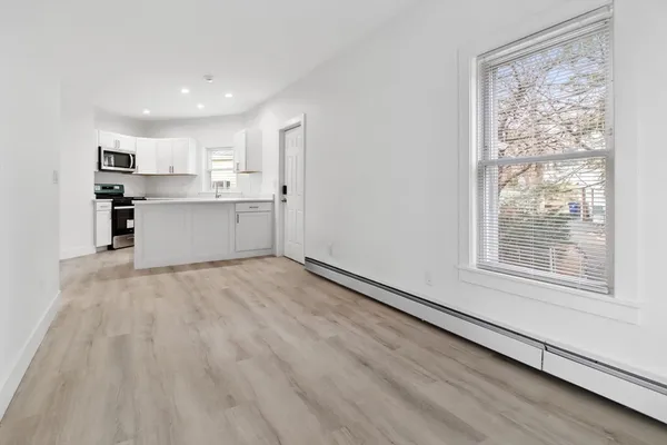 a view of a kitchen with wooden floor and a window