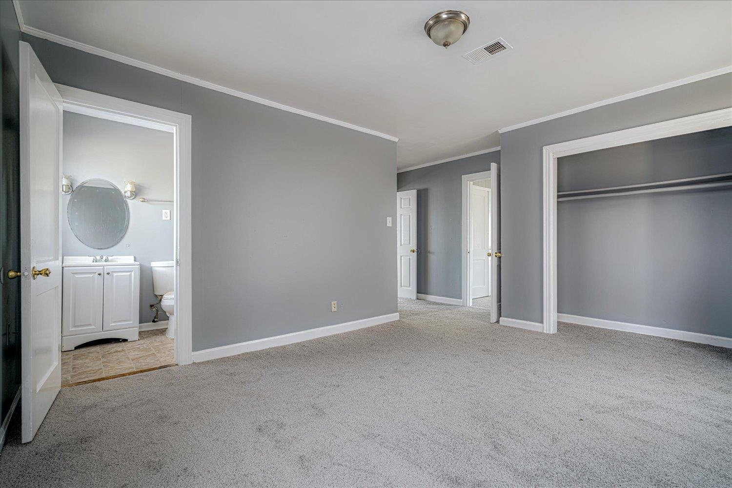 1114 Brownlee Road Memphis, TN 38116 - Photo 26 of 32 Unfurnished bedroom with light carpet, a closet, crown molding, and connected bathroom