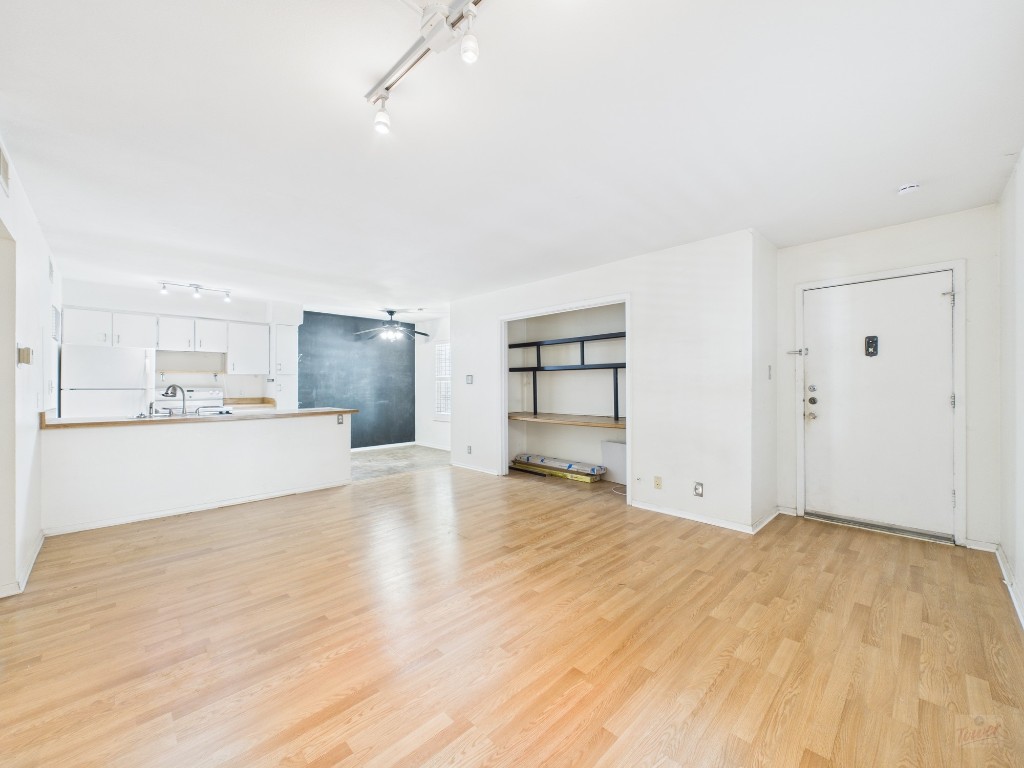 910 Duncan Lane, Unit 26 Austin, TX 78705 - Photo 13 of 31 a view of empty room with wooden floor and kitchen