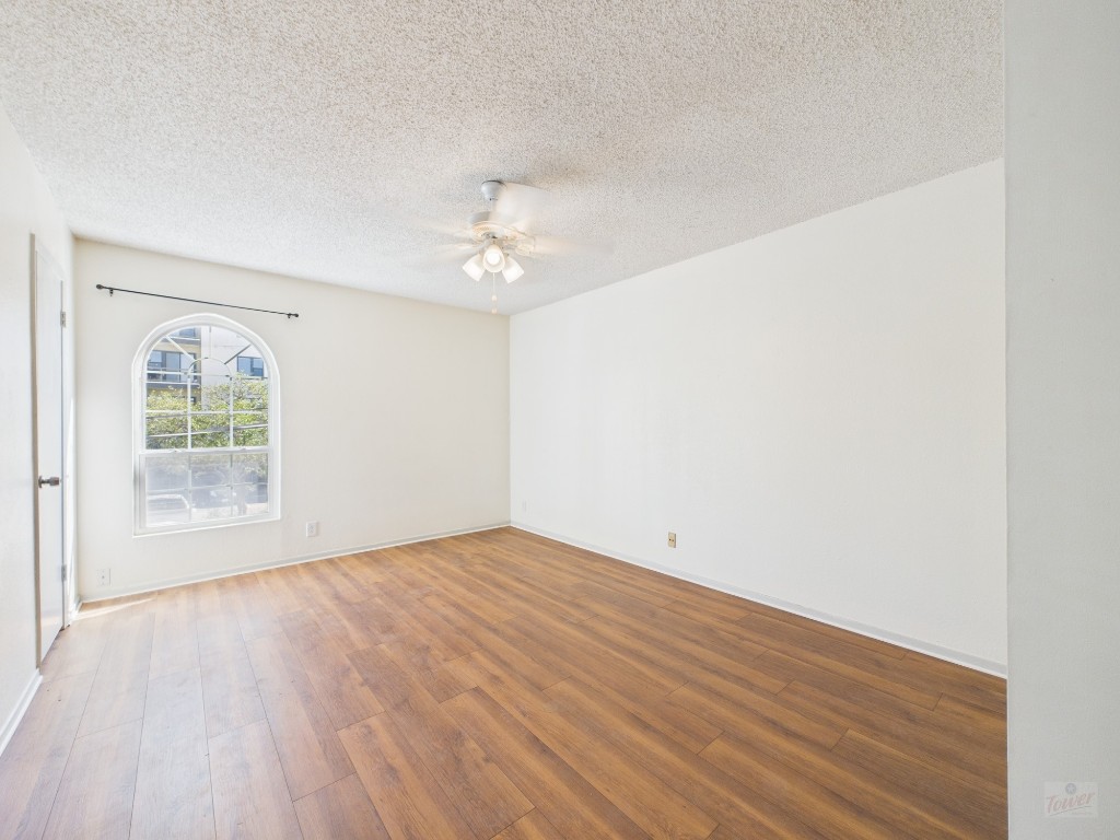 910 Duncan Lane, Unit 26 Austin, TX 78705 - Photo 24 of 31 an empty room with wooden floor and windows